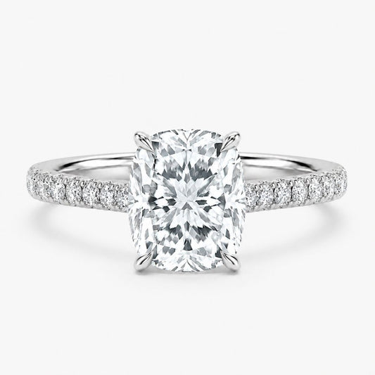 An engagement ring featuring a large rectangular cushion-cut center diamond in a four-prong setting, with a polished silver-colored band adorned with pavé diamonds on each side, set against a clean white background.