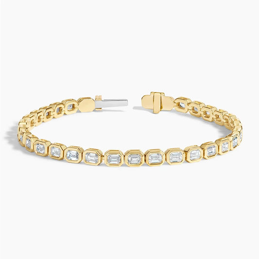 Yellow gold tennis bracelet with emerald-cut lab-grown diamonds on a white background