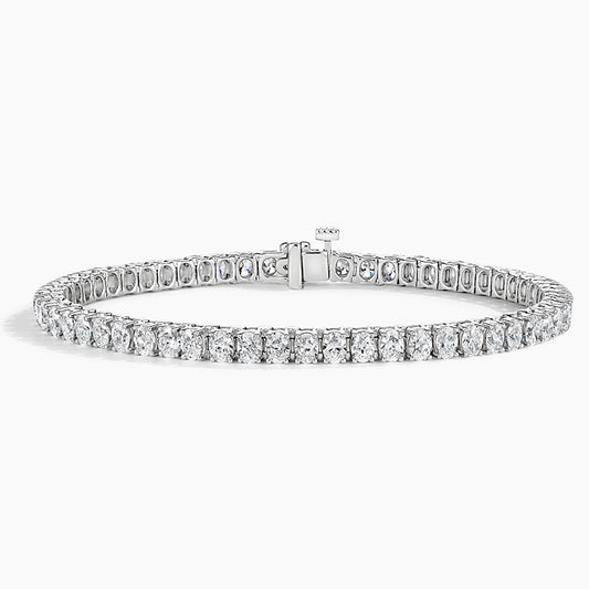 Oval cut diamond tennis bracelet in white gold with secure clasp on white background