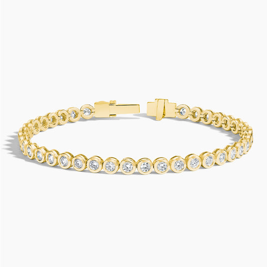 Yellow gold tennis bracelet with round lab-grown diamonds, bezel set, on white background