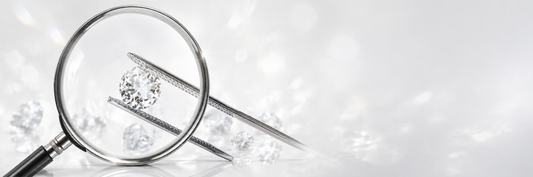 Round brilliant diamond held by tweezers under magnifying glass showing diamond inspection and grading