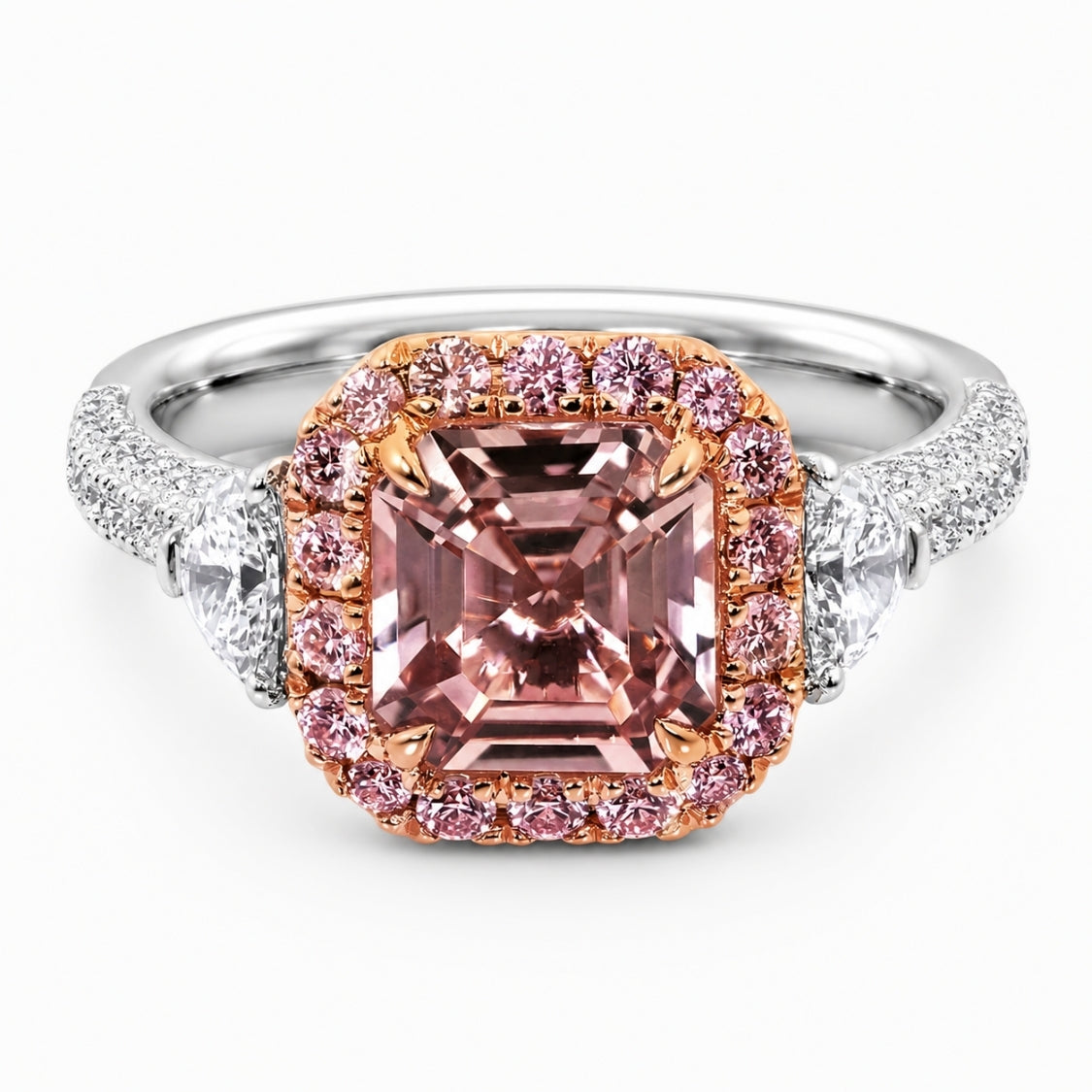 A luxury ring featuring a large cushion-cut pink molybdenite center stone in a rose gold halo, set on a silver-colored band with pavé diamonds and round diamonds, shot against a clean white background.