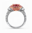 A high-end diamond and gemstone ring featuring a large cushion-cut pink center stone surrounded by smaller pink stones, set in a rose gold halo on a silver-toned band paved with clear diamonds, shown on a white background.