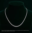 Diamond tennis necklace on a black velvet stand with a dark background, ecomposer-metal type-white-gold-18k, ecomposer-metal type-yellow-gold-18k, ecomposer-metal type-rose-gold-18k