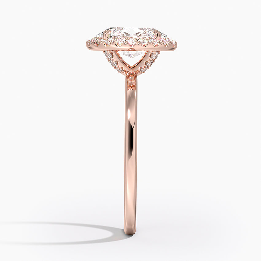 Side view of rose gold halo oval diamond engagement ring with pavé band