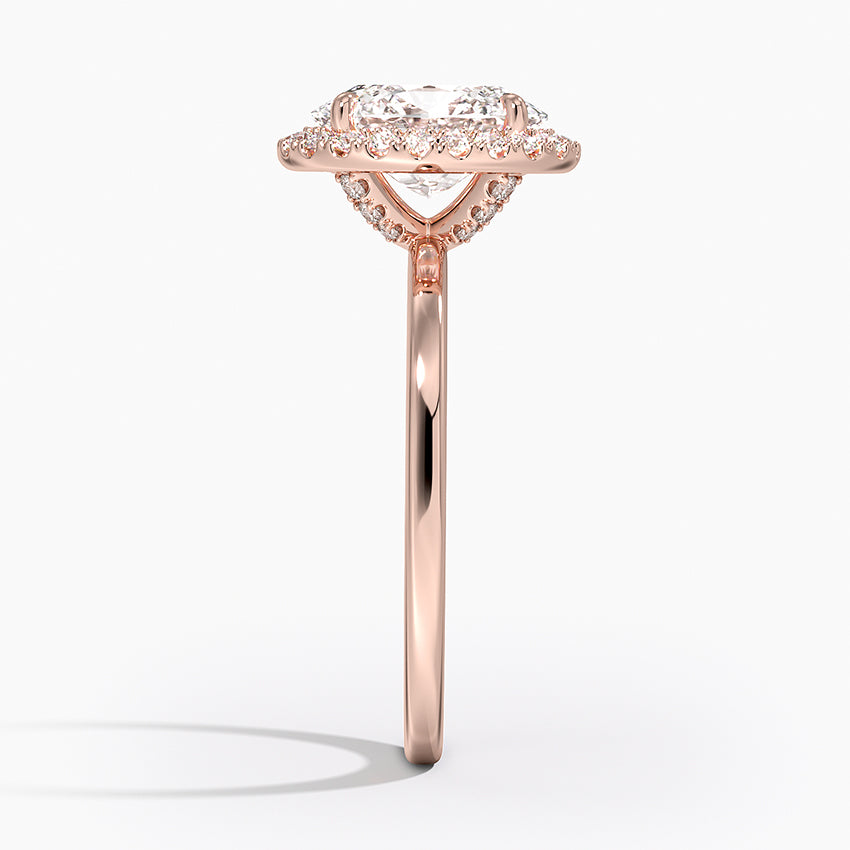 Side view of oval halo rose gold engagement ring with lab-grown diamond and pavé accents.