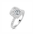 A cushion-cut diamond halo ring in white gold or platinum, featuring a large central diamond surrounded by a halo and a pavé-set band, shown on a clean white background.