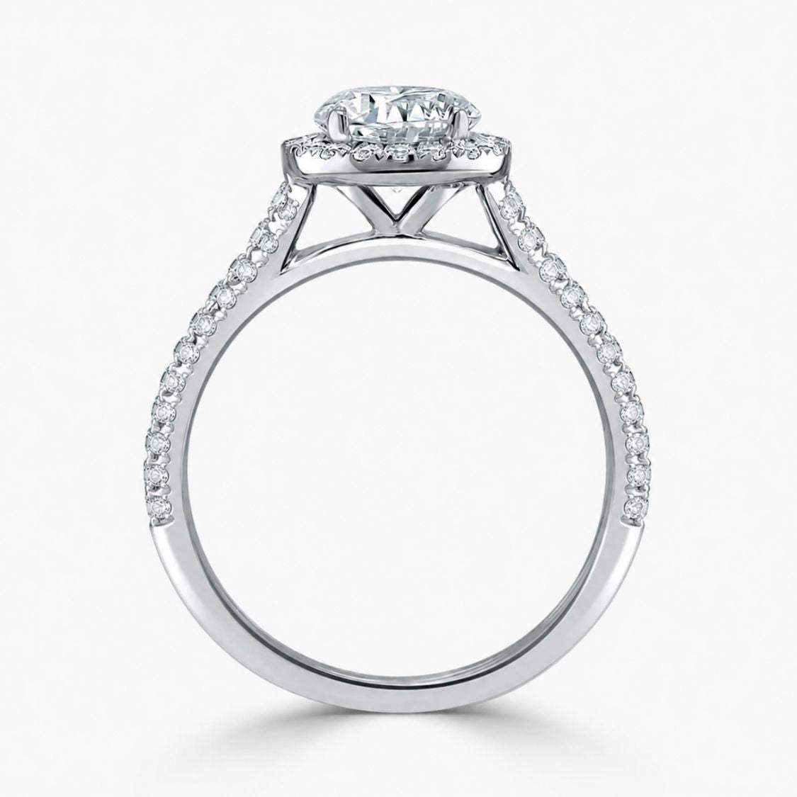 A silver-toned diamond engagement ring with a round-cut center stone and a halo of smaller diamonds, set against a clean white background.
