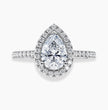 A pear-cut halo ring featuring a large clear pear-cut center stone surrounded by a halo of smaller round stones, with a pavé-set band, shown on a light gray background.