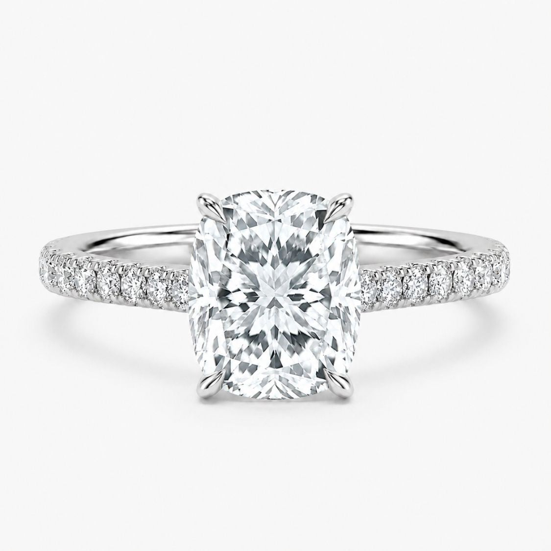 An engagement ring featuring a large rectangular cushion-cut center diamond in a four-prong setting, with a polished silver-colored band adorned with pavé diamonds on each side, set against a clean white background.