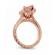 A rose gold engagement ring featuring a large, round pink gemstone in a prong setting, with a decorative filigree band accented by small pink stones, shown on a white background, ecomposer-metal type-rose-gold-18k