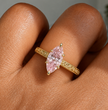 A gold vintage engraved band ring with a marquise-cut pink gemstone, shown worn on a finger, ecomposer-metal type-yellow-gold-18k
