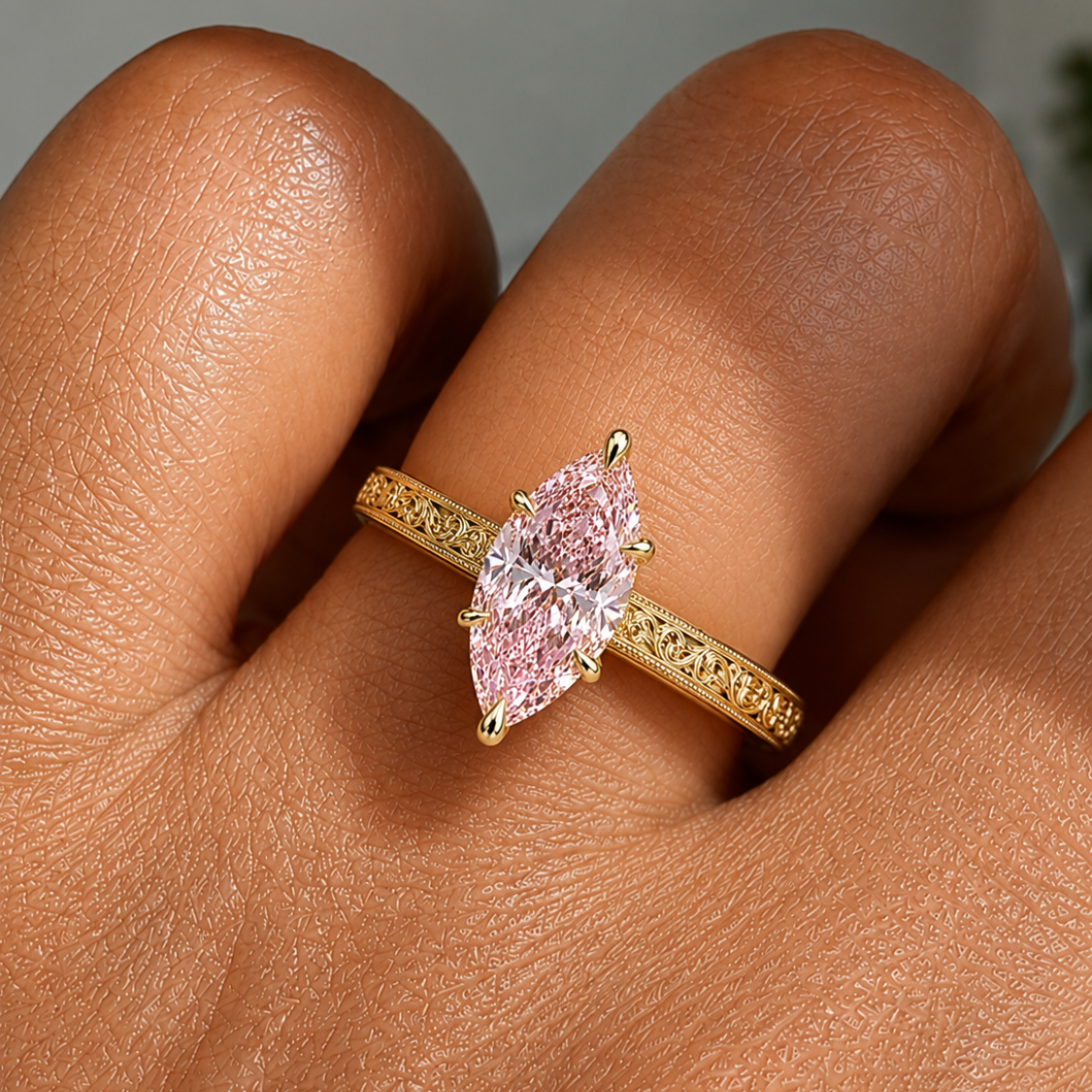 A gold vintage engraved band ring with a marquise-cut pink gemstone, shown worn on a finger, ecomposer-metal type-yellow-gold-18k
