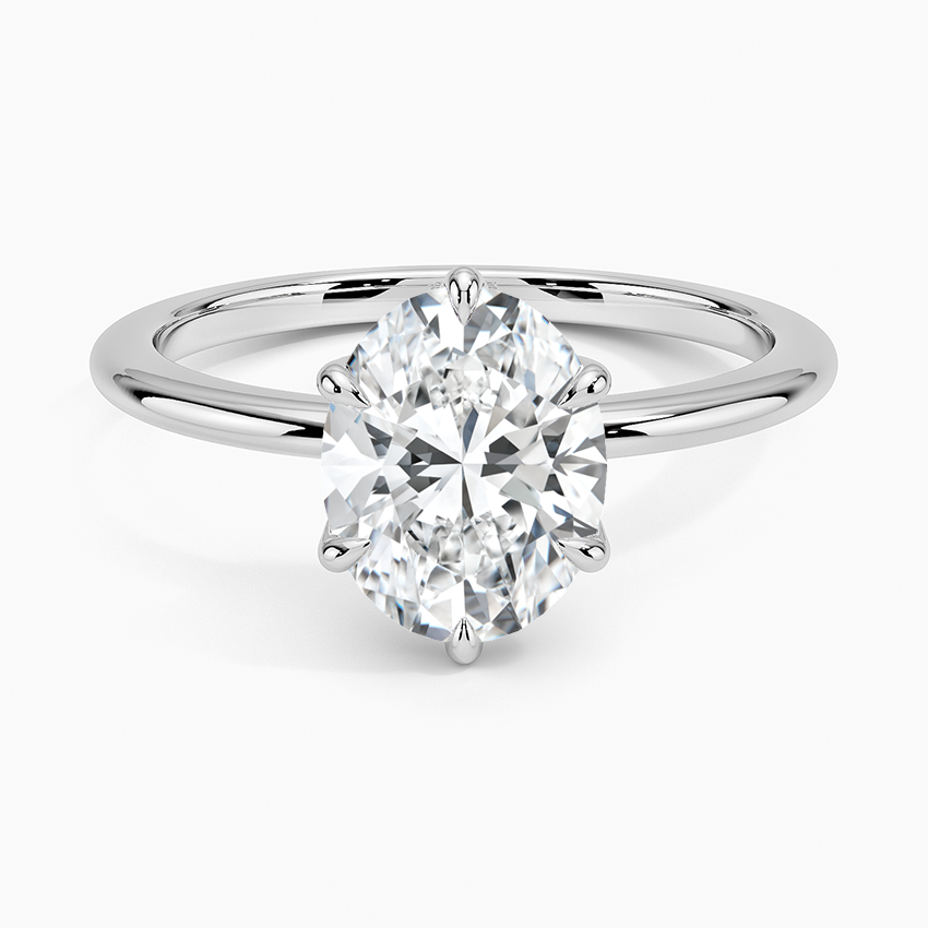 Oval-cut solitaire diamond engagement ring with white gold band on white background