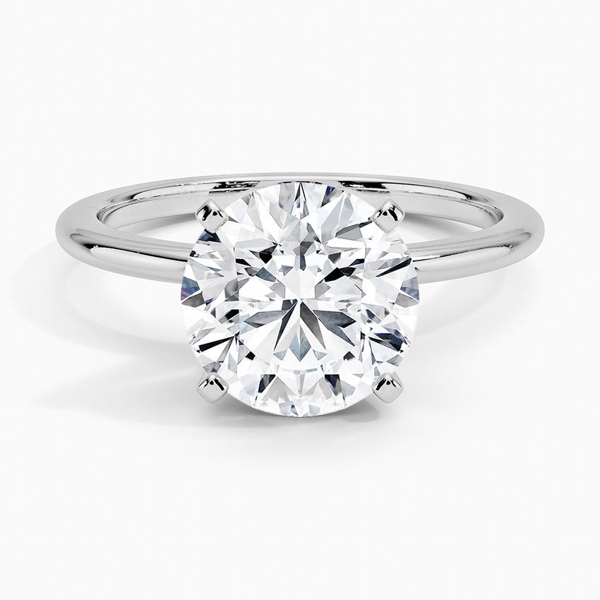 Round solitaire lab-grown diamond engagement ring with a white gold band and four-prong setting